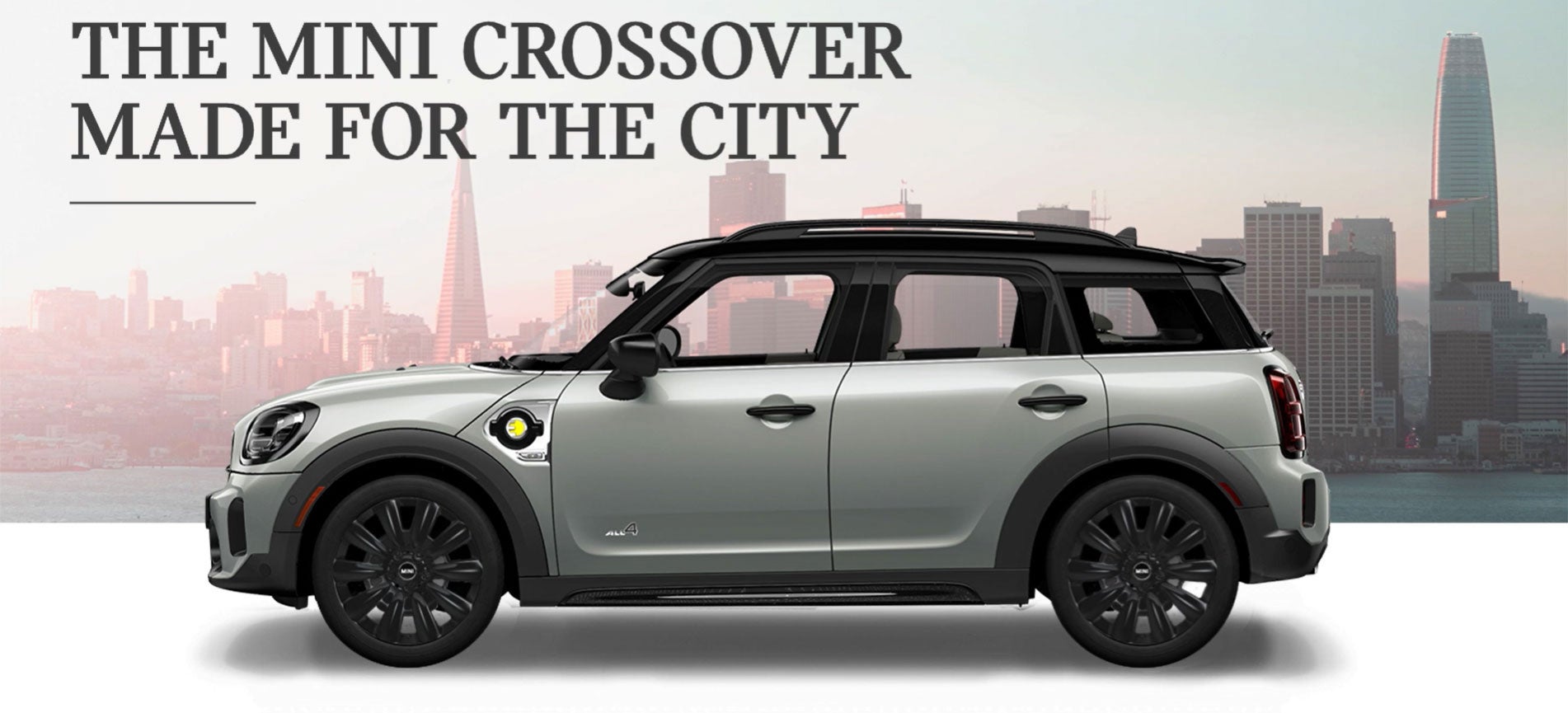 The MINI Cooper SE Countryman PHEV parked in front of a city scape. MINI of Alexandria in Alexandria VA