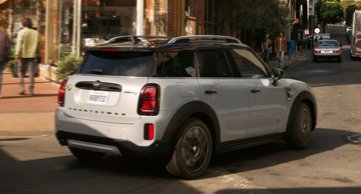 The MINI Cooper SE Countryman PHEV turning a corner in the city. MINI of Alexandria in Alexandria VA