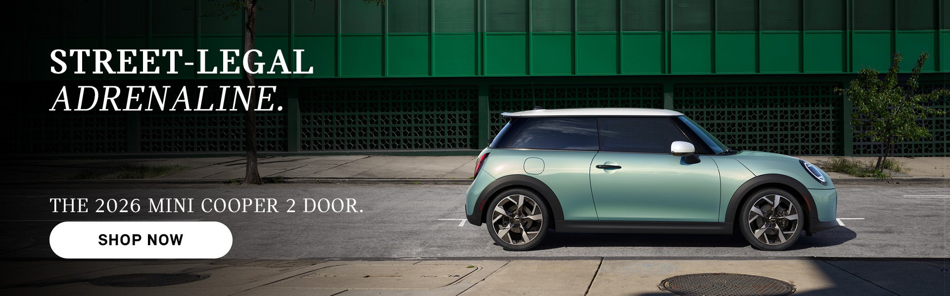 Mint green MINI Cooper 2-door parked on a city street with building backdrop, with ad text promoting the 2026 model 